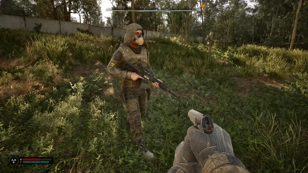 アタッチメント付きの銃を持って草地を歩くNPC