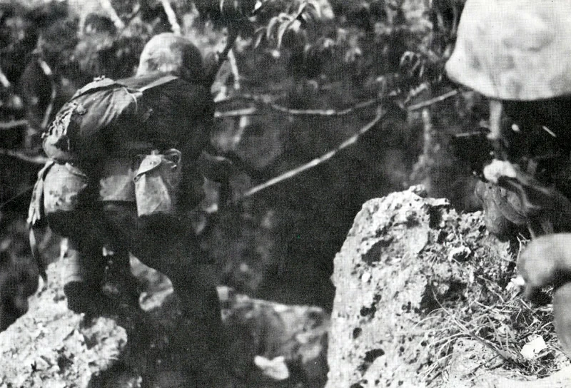 M1911を手にサイパンのジャングルを進む米海兵隊員(1944年)